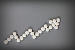 Benzos abuse, Abuse of Benzos Is on the Rise - white pills making arrow graph on grey background