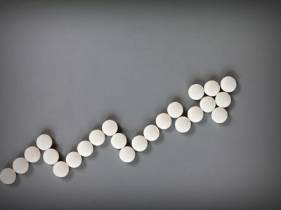 Abuse of Benzos Is on the Rise - white pills making arrow graph on grey background