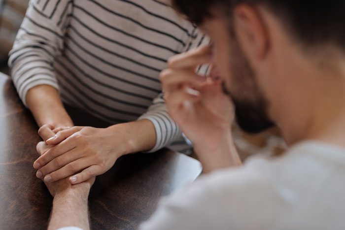 Ways to Support a Recovering Family Member, Ways Family Can Help in Recovery, sad man; woman holding hand