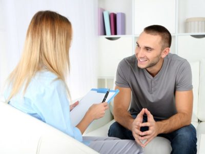 Continuum of Care Plan, recovery-oriented system of care, smiling man talking to female therapist