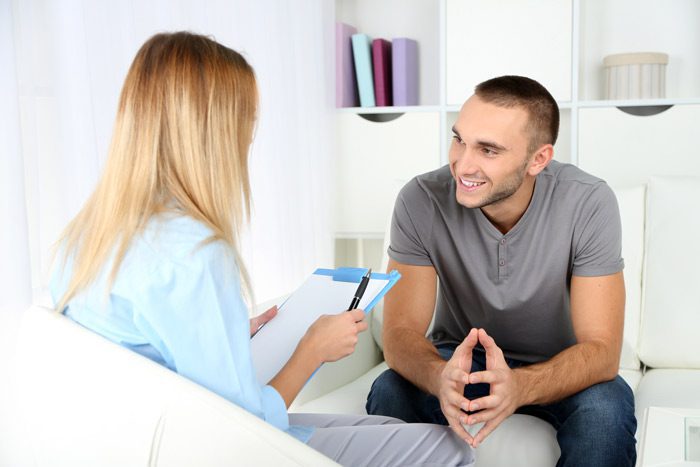 Continuum of Care Plan, recovery-oriented system of care, smiling man talking to female therapist