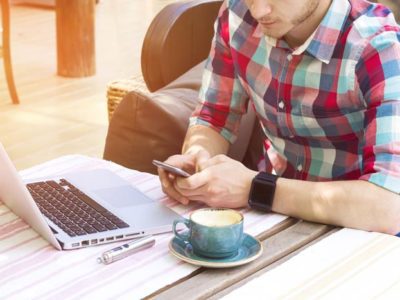 man researching with phone and computer