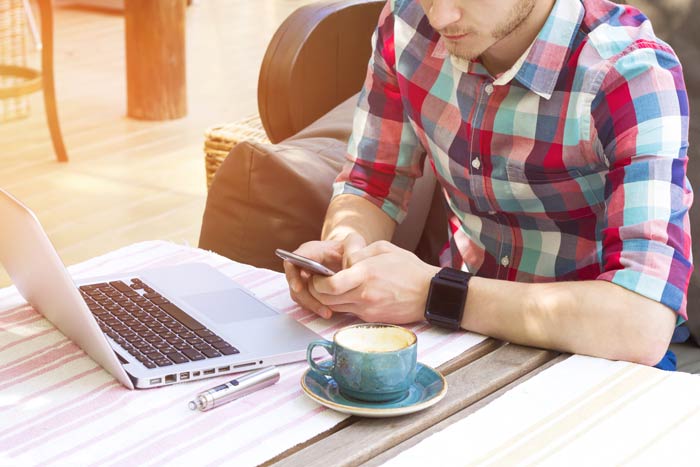 man researching with phone and computer