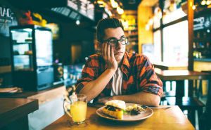 man with no appetite in restaurant