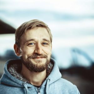 Embracing Emotional Sobriety:, smiling content man in grey hooded sweatshirt - emotional sobriety