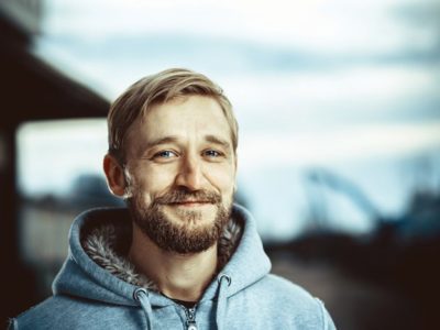 Embracing Emotional Sobriety:, smiling content man in grey hooded sweatshirt - emotional sobriety