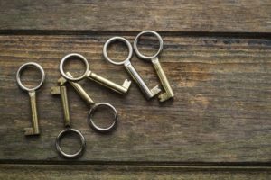 6 old fashioned metal keys laying on wooden table - life