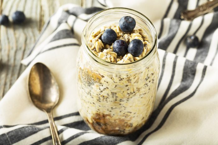 overnight oats in mason jar topped with fresh blueberries - stress