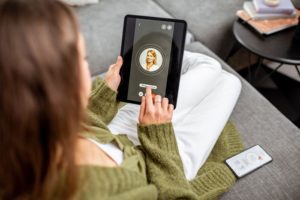 woman using tablet computer at home to video call doctor - telemedicine - telehealth - addiction recovery