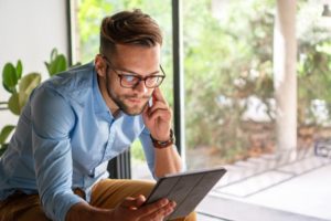 handsome young man on phone and tablet computer - treatment - COVID-19