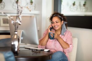 Addiction, Substance Use and Recovery during the COVID-19, Substance use during the pandemic, woman sitting at home in front of computer on cell phone drinking coffee - your loved one - pandemic
