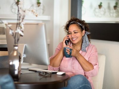 Addiction, Substance Use and Recovery during the COVID-19, Substance use during the pandemic, woman sitting at home in front of computer on cell phone drinking coffee - your loved one - pandemic