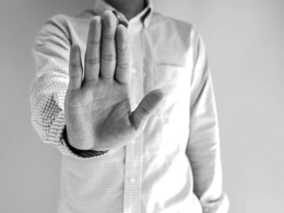 HALT, black and white image of man holding his hand out in a stop gesture - HALT - COVID-19