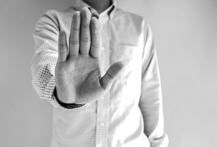 HALT, black and white image of man holding his hand out in a stop gesture - HALT - COVID-19