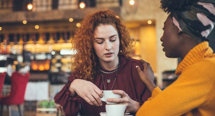 girl supporting her friend as they talk over coffee - loved one