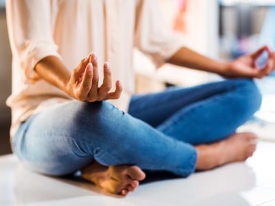 woman sitting on desk or table meditating - emotions