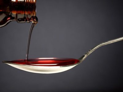 close up of cough syrup being poured into a spoon - codeine cough syrup