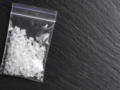 baggie of clear white crystals on slate background - meth addiction