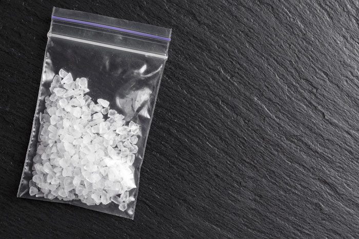 baggie of clear white crystals on slate background - meth addiction