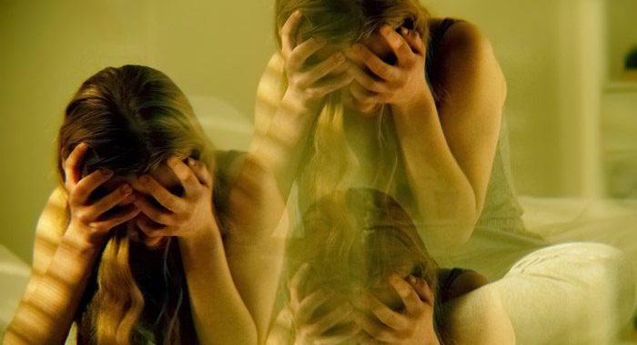 triple exposure image of young girl with her head in her hands - room spinning and high on drugs - club drugs