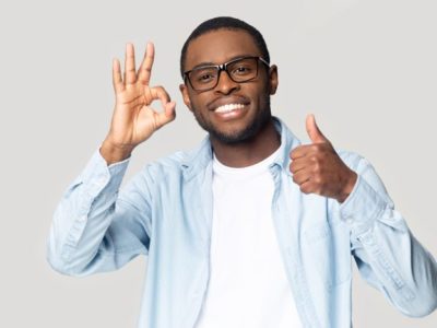 Addiction is a chronic illness, Chronic Illnesses, smiling Black man in glasses giving the thumbs up with one hand and the okay sign, with the other - chronic illnesses