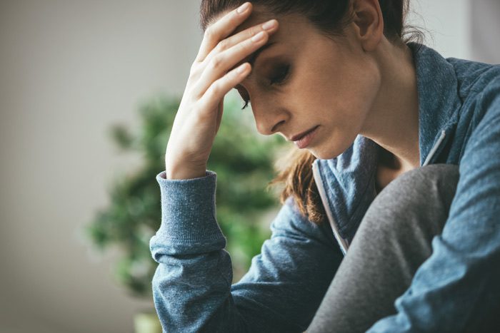 thin-faced young woman looking sad - body dysmorphic disorder