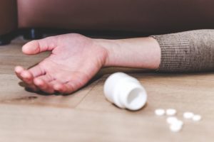 Drug Overdose, Prevent Substance Use Overdose Death, Risk Factors of Drug Overdose, cropped shot of arm next to spilled bottle of pills - drug overdose