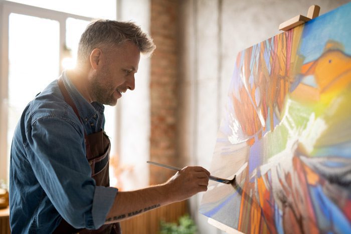 handsome man painting in his studio - reduce stress