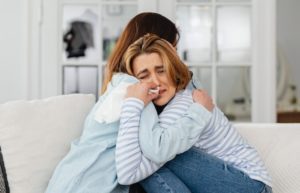 girl hugging sorry forgive addiction treatment recovery