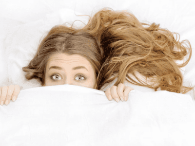A woman hiding in bed.