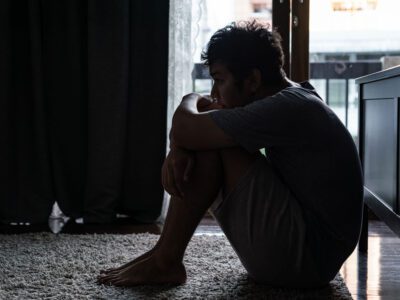 sad man sitting on the floor in the dark
