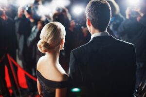 Celebrities posing for paparazzi on red carpet