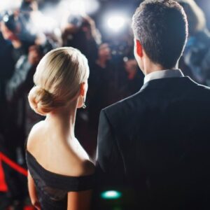 Celebrities posing for paparazzi on red carpet