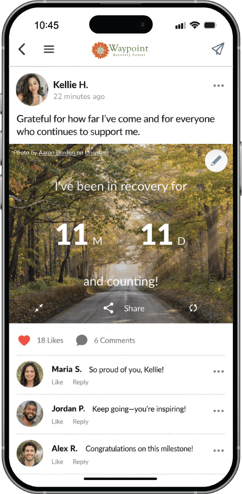A smartphone displaying a social media post from Waypoint Recovery Center where a user named Kellie H. celebrates 11 months and 11 days of recovery with an image of a tree-lined road.